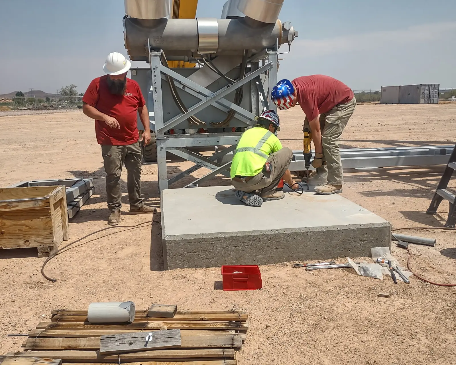 Crew anchoring a new circuit breaker to its concrete foundation pad